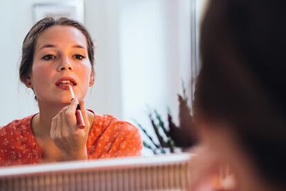 Un mujer aplicándose maquillaje.