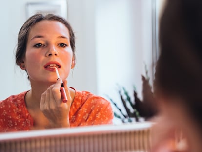 Un mujer aplicándose maquillaje.