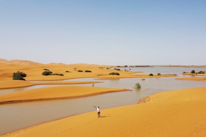 Un hombre camina junto a un lago formado tras las lluvias caídas en el desierto de Merzouga (Marruecos), el 2 de octubre. 