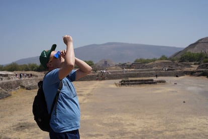 Un turista observa el inicio del eclipse desde el centro arqueológico de Teotihuacán en México.