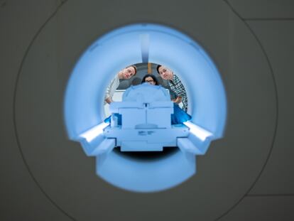 Los investigadores (de izquierda a derecha) Alex Huth, Shailee Jain y Jerry Tang, al fondo del escáner de resonancia magnética del Centro de Imagen Biomédica de la Universidad de Texas en Austin.