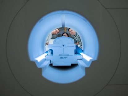 Los investigadores (de izquierda a derecha) Alex Huth, Shailee Jain y Jerry Tang, al fondo del escáner de resonancia magnética del Centro de Imagen Biomédica de la Universidad de Texas en Austin.