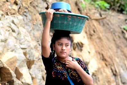 Una joven transporta ropa lavada por la nueva carretera.