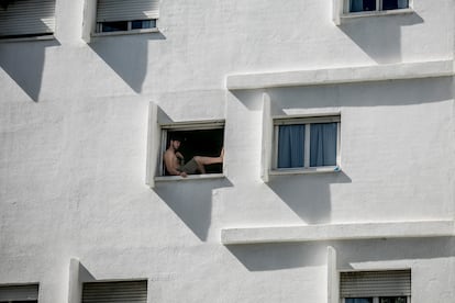 Un joven busca el fresco en el quicio de la ventana para sobrellevar la ola de calor en Madrid el 26 de abril.