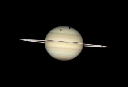 Cuatro de las lunas de Saturno cruzándose por delante de ese planeta fueron captadas por el telescopio espacial `Hubble´ el 24 de febrero de 2009. La gran luna Titán forma una sombra notable cerca del polo Norte de Saturno, y la de Mimas, un poco más cerca de los anillos, es más pequeña.