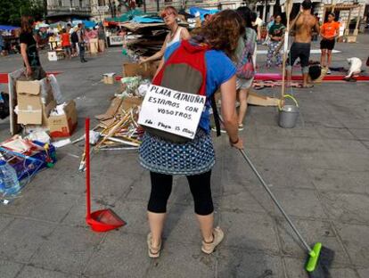 Varios acampados del 15-M limpian la Plaza del Ayuntamiento de Valencia.