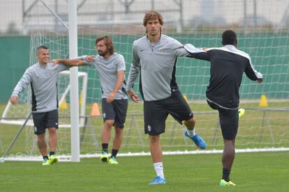 Fernando Llorente realiza ejercicios de estiramientos con Pogba, en el entrenamiento del Juventus.