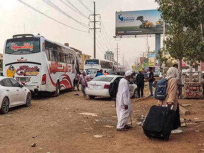Algunas personas se preparan para abordar un autobús que sale de Jartum este lunes.