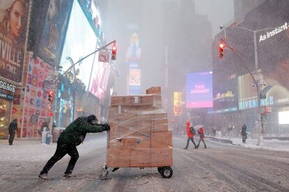 Un hombre trata de entregar paquetes en Times Square durante una fuerte nevada en Manhattan, Nueva York.