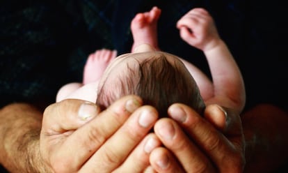 Un padre sujeta a su recién nacido. Los padres primerizos se enfrentan a muchos retos.