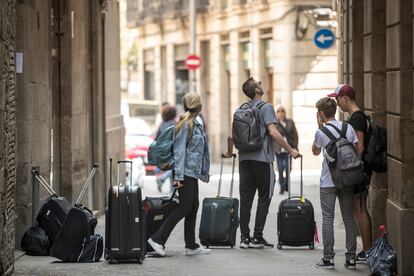 Turistas con maletas ante un edificio del barrio Gòtic de Barcelona, en una imagen de archivo.