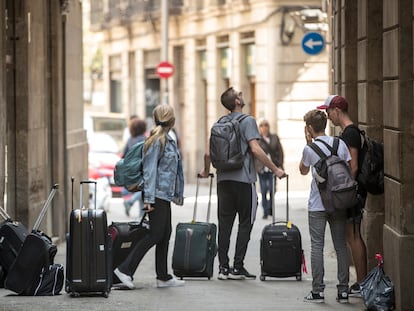 Turistas con maletas ante un edificio del barrio Gòtic de Barcelona, en una imagen de archivo.
