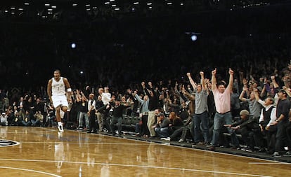 Joe Johnson y los aficionados de los Brooklyn Nets reaccionan tras anotar el tiro de la victoria ante los Pistons.