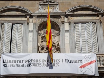 Balcón del edificio de la Generalitat con pancarta con lazo blanco y franja roja. 