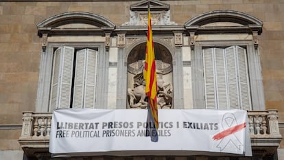 Balcón del edificio de la Generalitat con pancarta con lazo blanco y franja roja. 