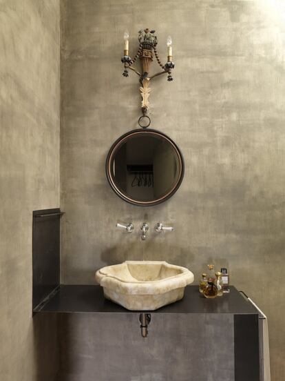 También las paredes de este baño han sido tratadas por el Studio Pelà. El lavamanos, que descansa sobre un mueble de cobre y hierro de la marca Chehoma, es de mármol de Carrara, y la lámpara, de finales del siglo XIX.