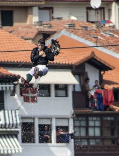 Un apresor vuela por los aires tras agarrarse al cuello de un ganso durante la fiesta de los Gansos de Lekeitio.