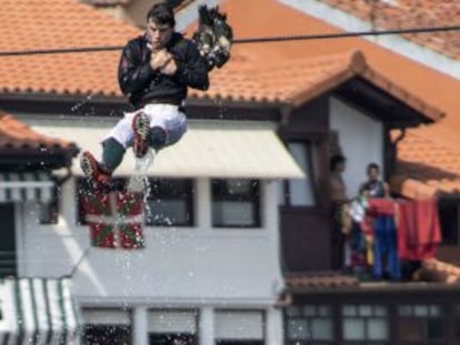 Un apresor vuela por los aires tras agarrarse al cuello de un ganso durante la fiesta de los Gansos de Lekeitio.