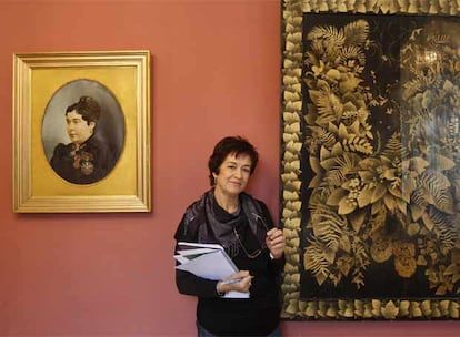 Matilde Torres, entre un retrato de la malagueña Emilia Rebollo y uno de sus cuadros.