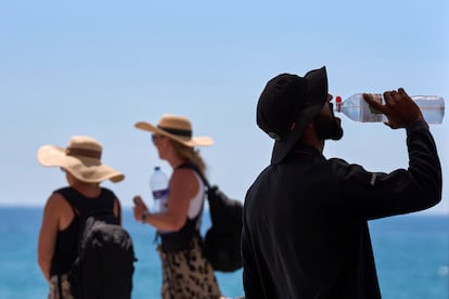 Un turista bebe agua en un día caluroso en la playa de Barcelona, España, el pasado 2 de julio.