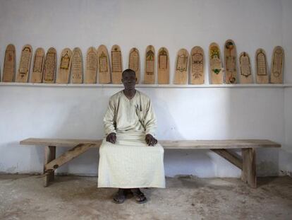 Aboubakar Yaro, jefe de conservaci&oacute;n de la Biblioteca de Djenne (Mal&iacute;), delante de algunos manuscritos sobre madera del Cor&aacute;n. 