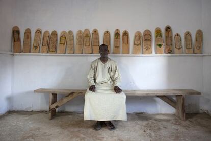 Aboubakar Yaro, jefe de conservaci&oacute;n de la Biblioteca de Djenne (Mal&iacute;), delante de algunos manuscritos sobre madera del Cor&aacute;n. 