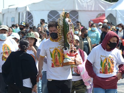 Un peregrino carga una efigie de la Virgen de Guadalupe, a las afueras de La Villa, en Ciudad de México, el 12 de diciembre de 2021.