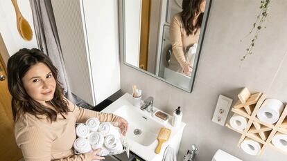 Una chica en el baño con un organizador de toallas en la mano