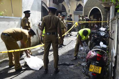 Personal de seguridad recoge pruebas en el exterior de la iglesia de Batticaloa tras el atentado terrorista ,este domingo.
