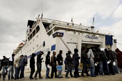 Inmigrantes tunecinos llegados a la isla italiana de Lampedusa son trasladados ayer a un centro de internamiento.