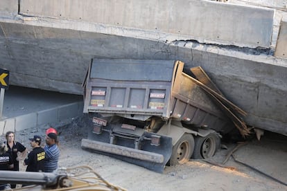 Um dos caminhões presos debaixo do viaduto.