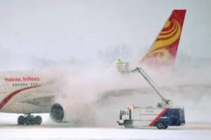 A un avión de la aerolínea Hainan se le retira el hielo de su fuselaje en el aeropuerto internacional Liszt Ferenc de Budapest, Hungría. EFE/Archivo
