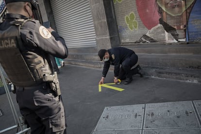 Policías colocan señalética en el piso para indicar el tránsito de las personas.