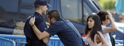 Una de las personas que han acudido a Sol se abraza a uno de los policías allí desplegado.