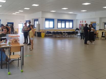 Apoderados y electores en el colegio Sagunto, en el barrio de San Cristóbal de los Ángeles, en Madrid, este domingo.