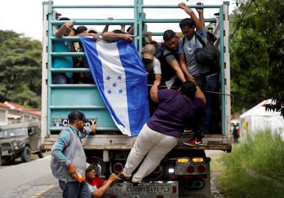 Una mujer hondureña se sube a un camión para integrarse a la caravana con destino a Estados Unidos, en Quezaltepeque (Guatemala), el 16 de octubre de 2017.