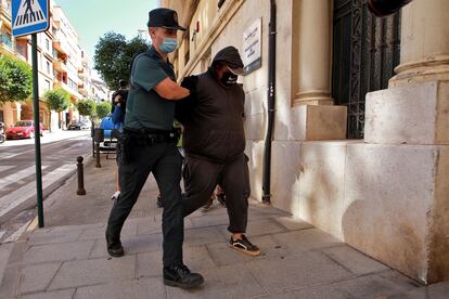 Un agente de la Guardia Civil traslada al Juzgado de Ontinyent, en Valencia, a uno de los detenidos.