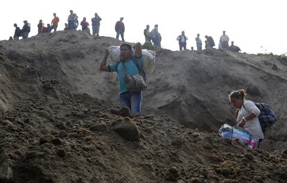 Los habitantes de El Cambray II de Santa Catarina Pinula miran el rescate después del derrumbe al ser evacuados.