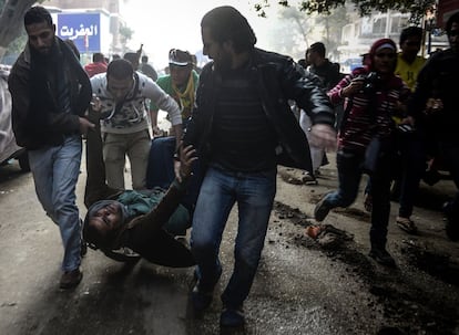 Un partidario del presidente islamista derrocado herido de muerte es evacuado por otros manifestantes durante los enfrentamientos con las fuerzas de seguridad en el distrito Mohandiseen de El Cairo.