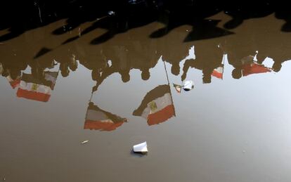 Banderas egipcias reflejadas en un charco durante la manifestación conmemorativa en la plaza de la Liberación.