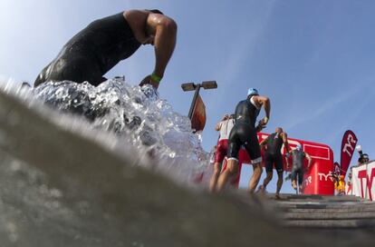 Triatletas terminando la primera prueba del Ironman, 3.86 km nadando en el Mar.