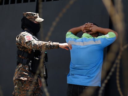 Un soldado detiene este lunes a un hombre en un punto de control en Santa Tecla (El Salvador).