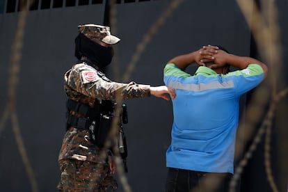 Un soldado detiene este lunes a un hombre en un punto de control en Santa Tecla (El Salvador)