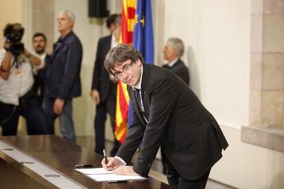 El expresidente de la Generalitat de Cataluña, Carles Puigdemont, firmando la declaración de independencia en el Parlamento de Cataluña, en octubre de 2017.