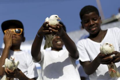 Crianças levantam pombas durante um protesto contra a intolerância nas ruas de Salvador (Brasil), em 15 de novembro de 2015.