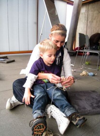 Una madre enseña a su hijo a tejer en el Museo de Arte, Listasafn, en Reikiavik (Islandia).