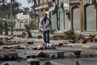 Un hombre atraviesa una calle sembrada de restos de barricadas levantadas por vecinos del barrio de Tajura, al este de Trípoli.