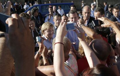 El presidente del Gobierno, Mariano Rajoy, y la canciller alemana, Angela Merkel, fotografiados a su llegada el domingo a la plaza del Obradoiro, tras recorrer un tramo del Camino de Santiago desde el municipio de O Pino (A Coruña). Ambos dirigentes recibieron abucheos por parte de vecinos y turistas.