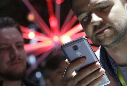 Un hombre mira su teléfono móvil.