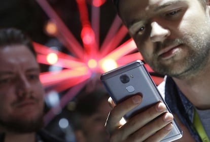 Un hombre mira su tel&eacute;fono m&oacute;vil.